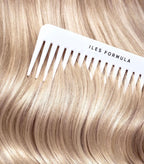Comb with 'ILES FORMULA' branding on a background of blonde hair