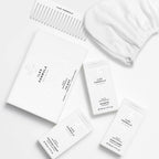 Limited Edition Travel Edit Flat Lay; The Minis Box, Mini Shampoo, Mini Conditioner, Mini Finishing Serum, Conditioning Distribution Comb, and Hair Turban Towel