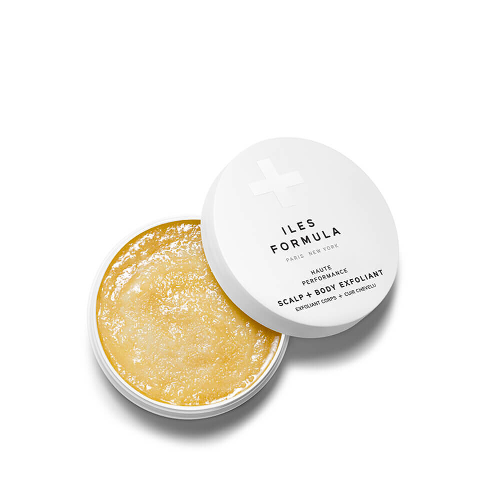 Open container of scalp and body exfoliant with 'ILES FORMULA' lid on a white background